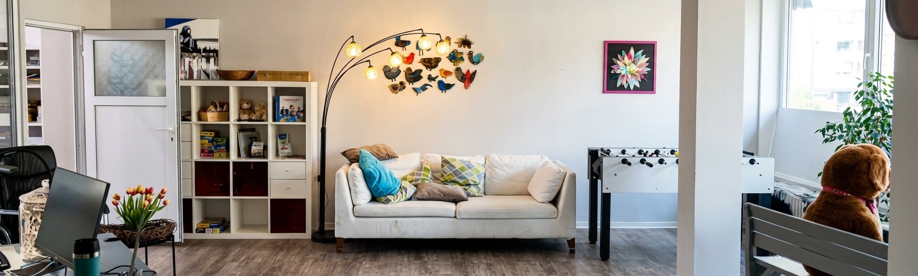 Unsere hellen Vereinsräume mit Sofa, Regal, Kickertisch und bunter Vogel-Lampe